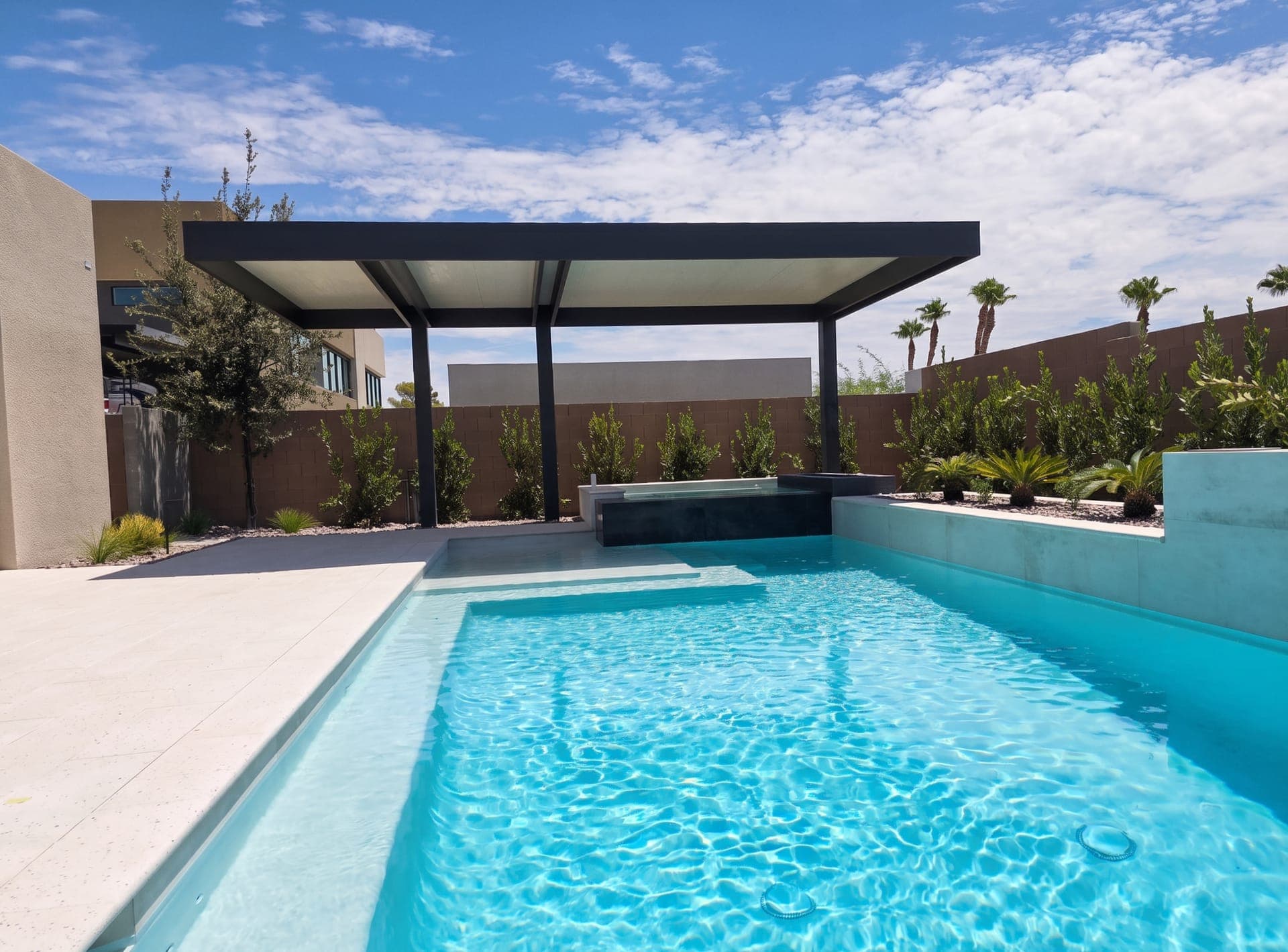 4K Aluminum cantilever cover with an insulated roof beside a modern pool and raised spa