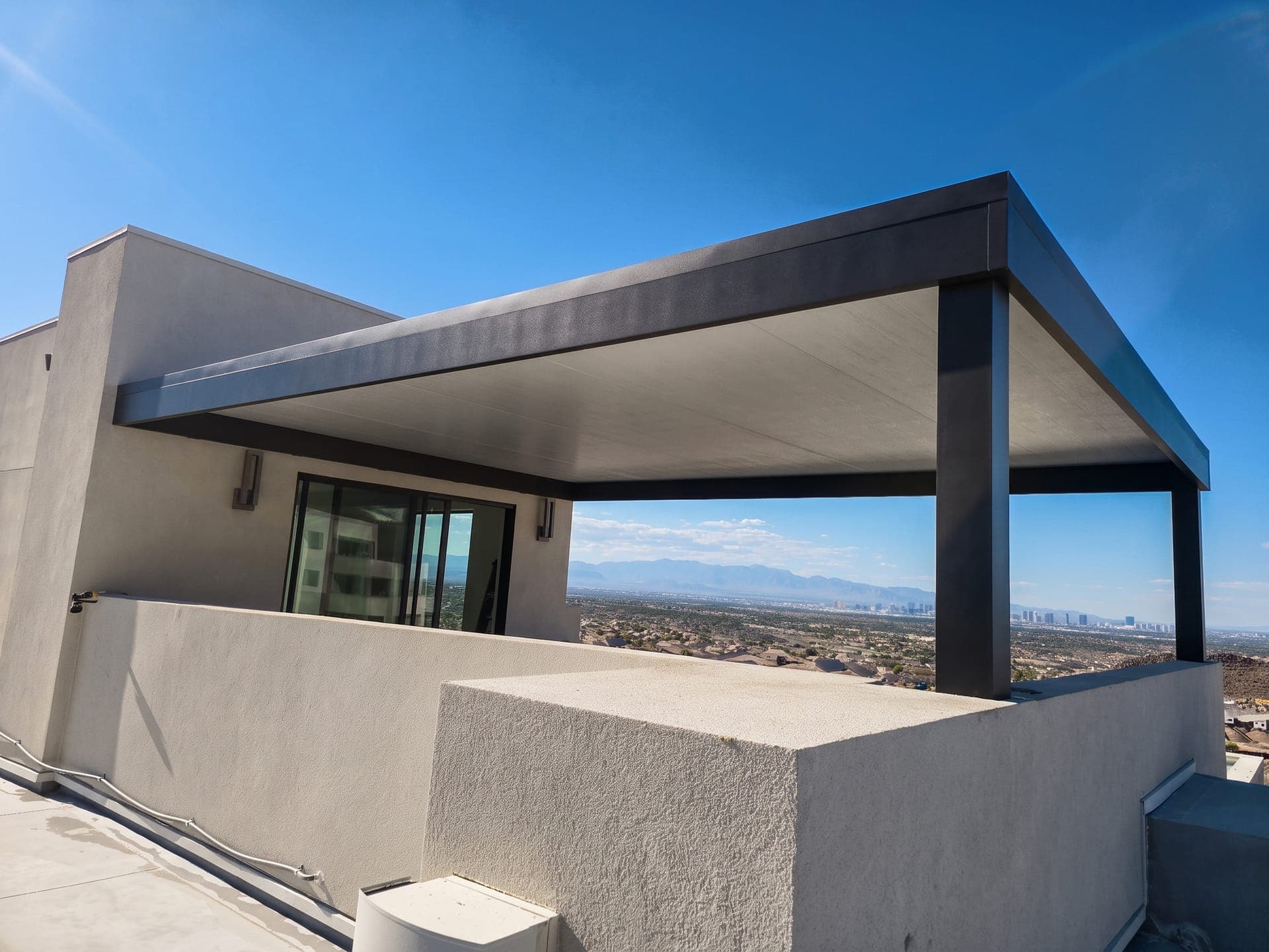 4K Aluminum patio cover with a solid roof attached to a second-story terrace, with the Las Vegas Strip in the distance